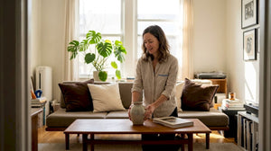 Woman arranging handmade vase in modern living room